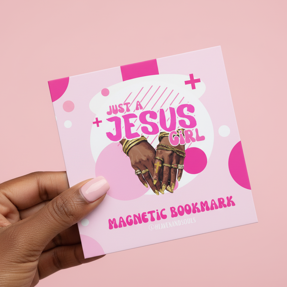 Pink magnetic bookmark with 'Just a Jesus Girl' text and hands holding a cross, held by a hand on a pink background.