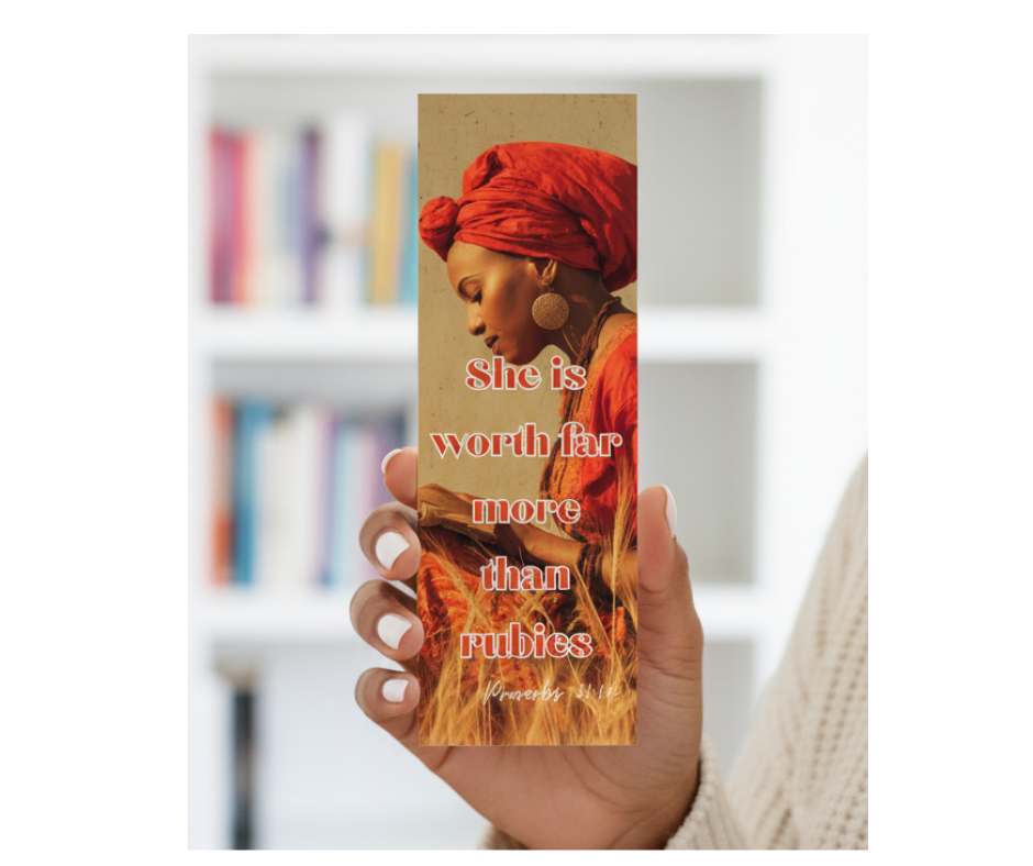 Hand holding a bookmark with a woman's portrait and text in a blurred bookshelf background