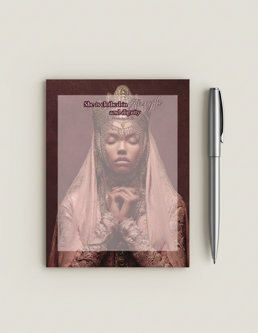 Notebook with a cover featuring a woman in a headscarf and text, next to a pen on a light background