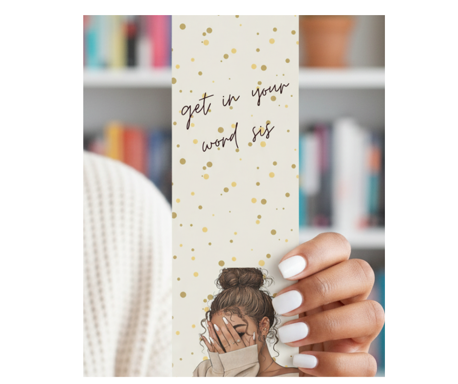 Bookmark with motivational text held by a hand in front of a bookshelf.