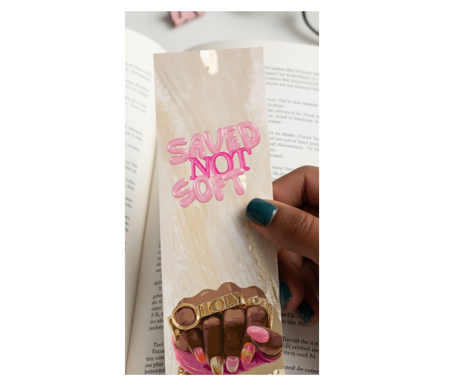 Bookmark with 'SAVED NOT SOFT' text and chocolate design held over an open book.