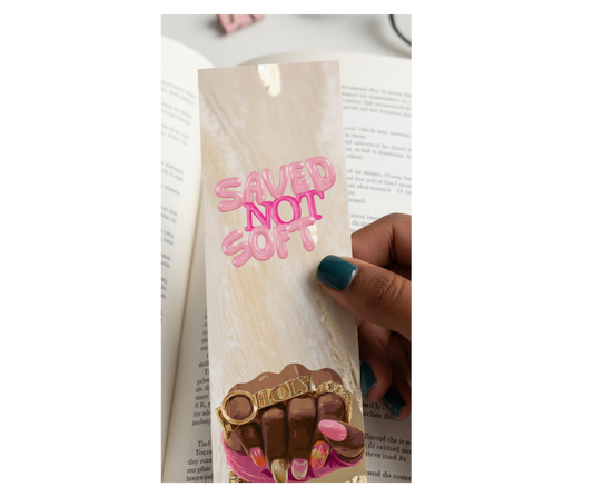 Bookmark with 'SAVED NOT SOFT' text and chocolate design held over an open book.