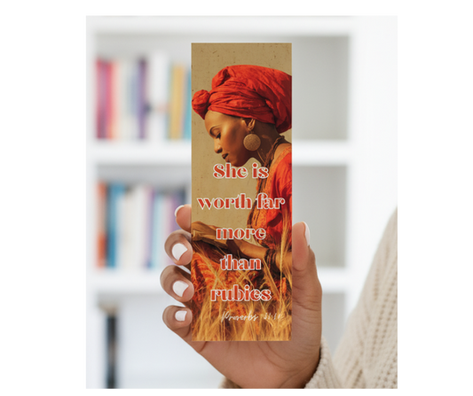 Hand holding a bookmark with a woman's portrait and text in a blurred bookshelf background